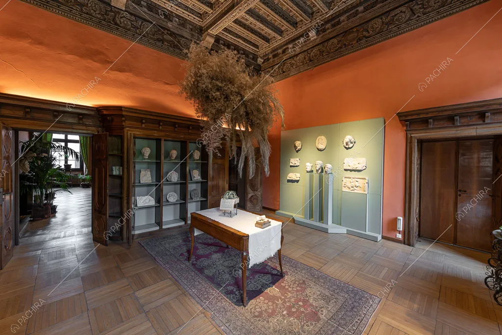 Tavolino in legno nella sala con pavimento in parquet e soffitto a cassettoni