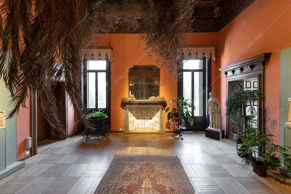 Pareti rosse nella sala con porte-finestre e pavimento in parquet