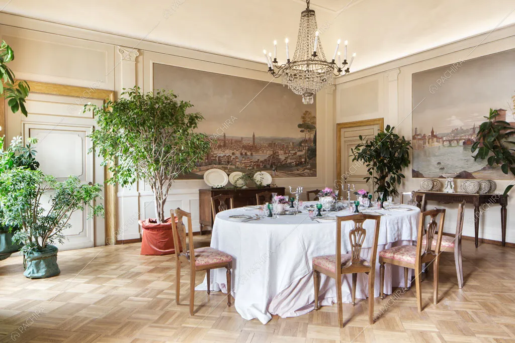 Luminosa sala da pranzo con boiserie alle pareti, pavimento in parquet e lampadario