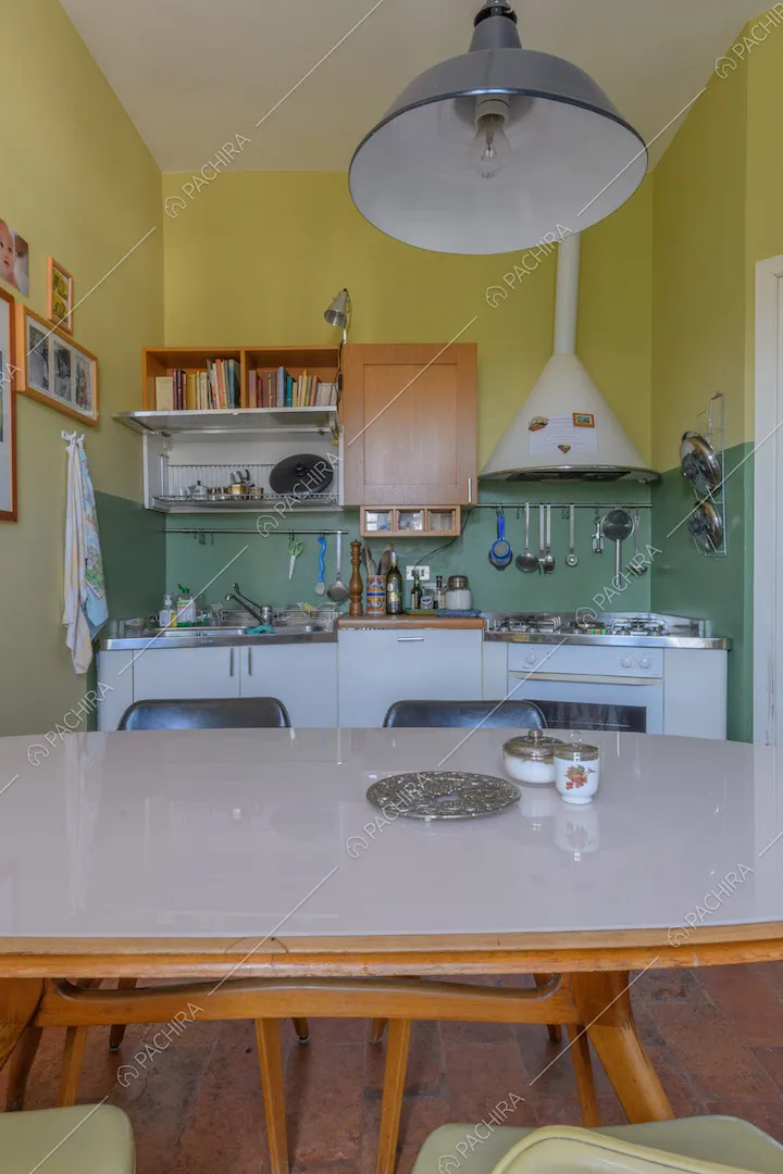 Tavolo bianco da pranzo nella cucina a parete gialla e verde