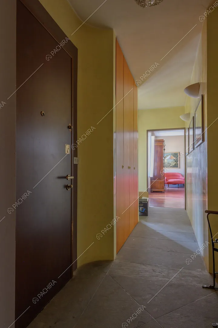 Ingresso con pavimento in pietra, pareti gialle e vista sulla zona living
