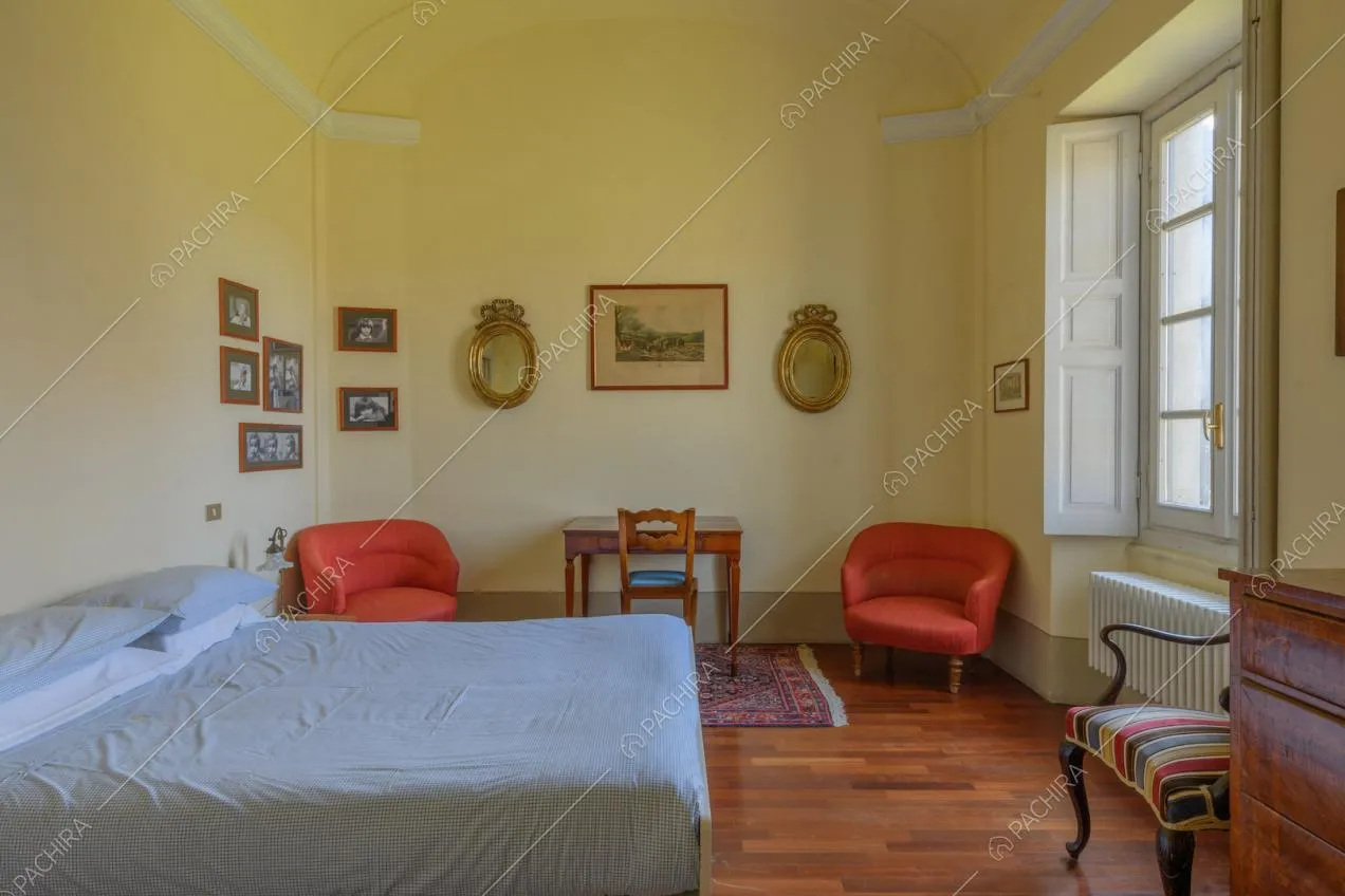 Grande camera da letto matrimoniale con pavimento in parquet e pareti gialle