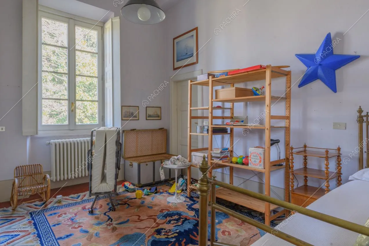Luminosa camera con letto dalla struttura in ottone e pareti azzurre