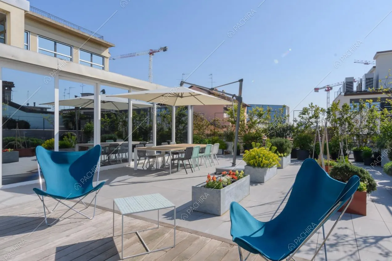 Sedie blu sulla terrazza con pavimento in parquet da esterni e tavolo da pranzo