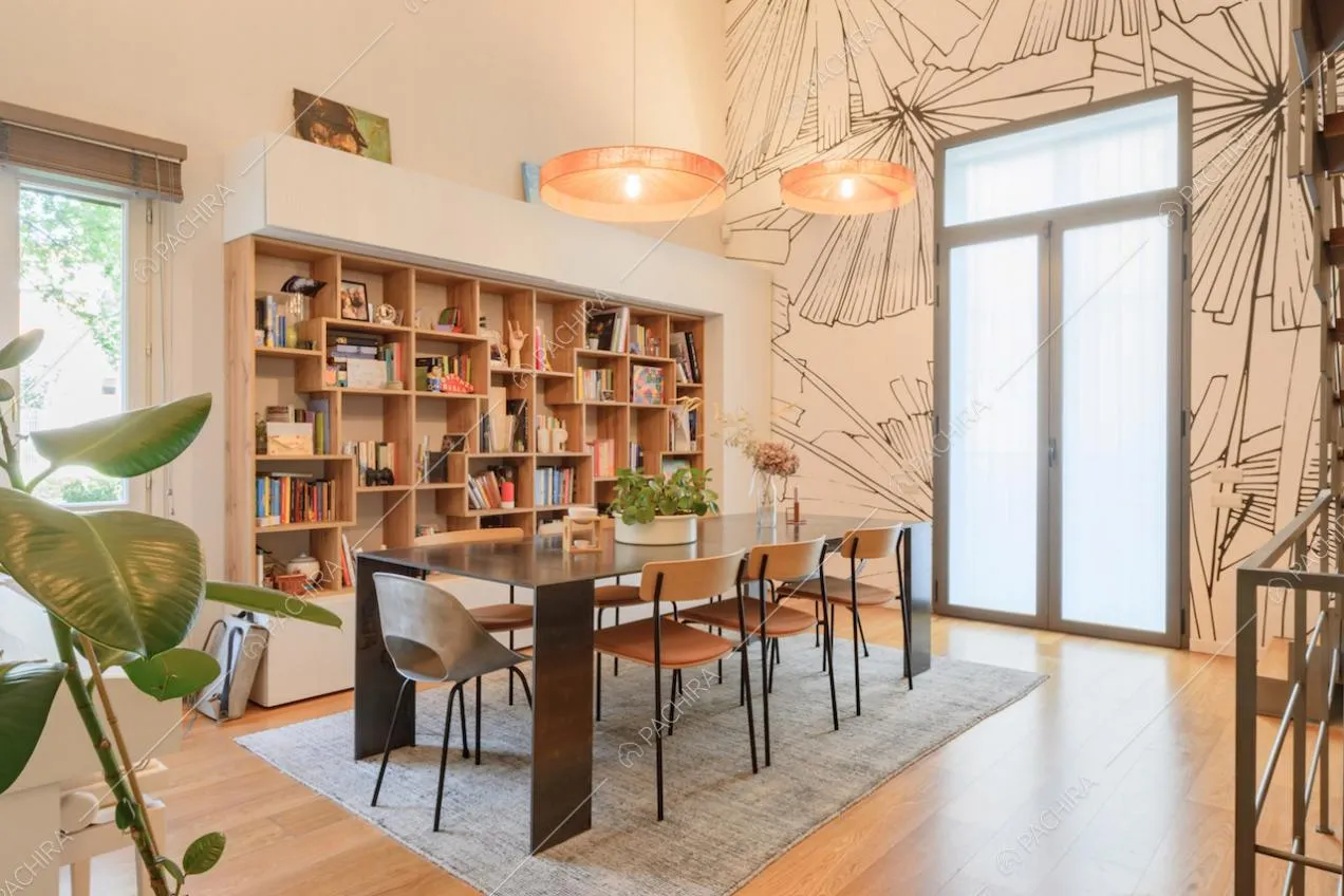 Tavolo da pranzo in metallo nero nella sala con libreria e carta da parati