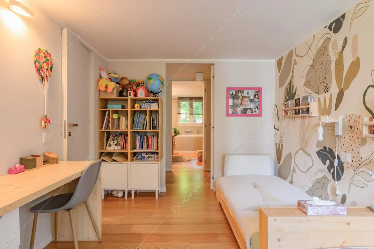Camera da letto dei bambini con carta da parati a tema floreale e vista sul bagno