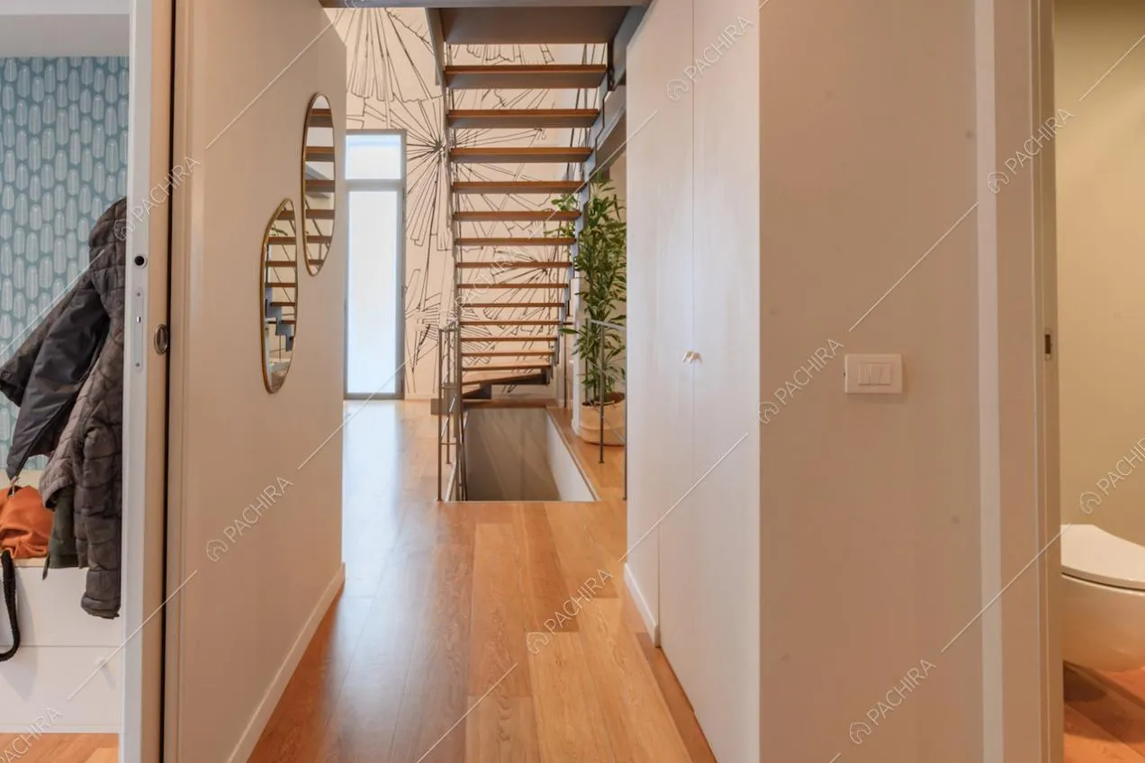 Corridoio con pavimento in parquet e vista sul vano scale e sulla carta da parati