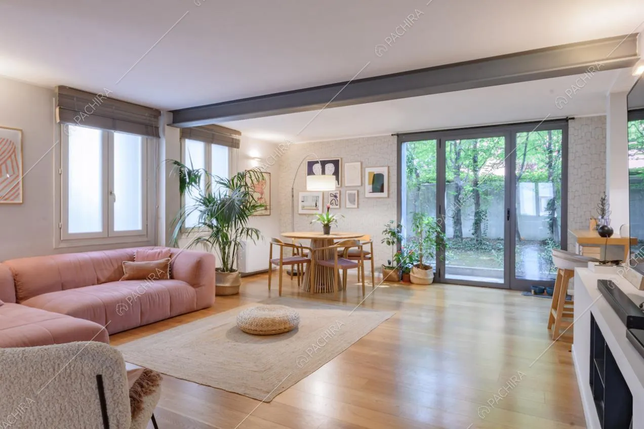 Pavimento in parquet, travi in metallo a vista e porta-finestra nel salotto