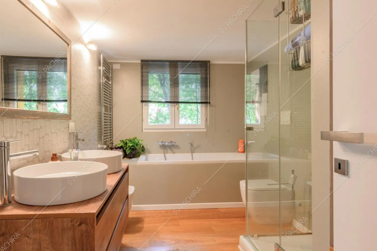 Pavimento in parquet nel bagno con vasca, box doccia e doppio lavandino
