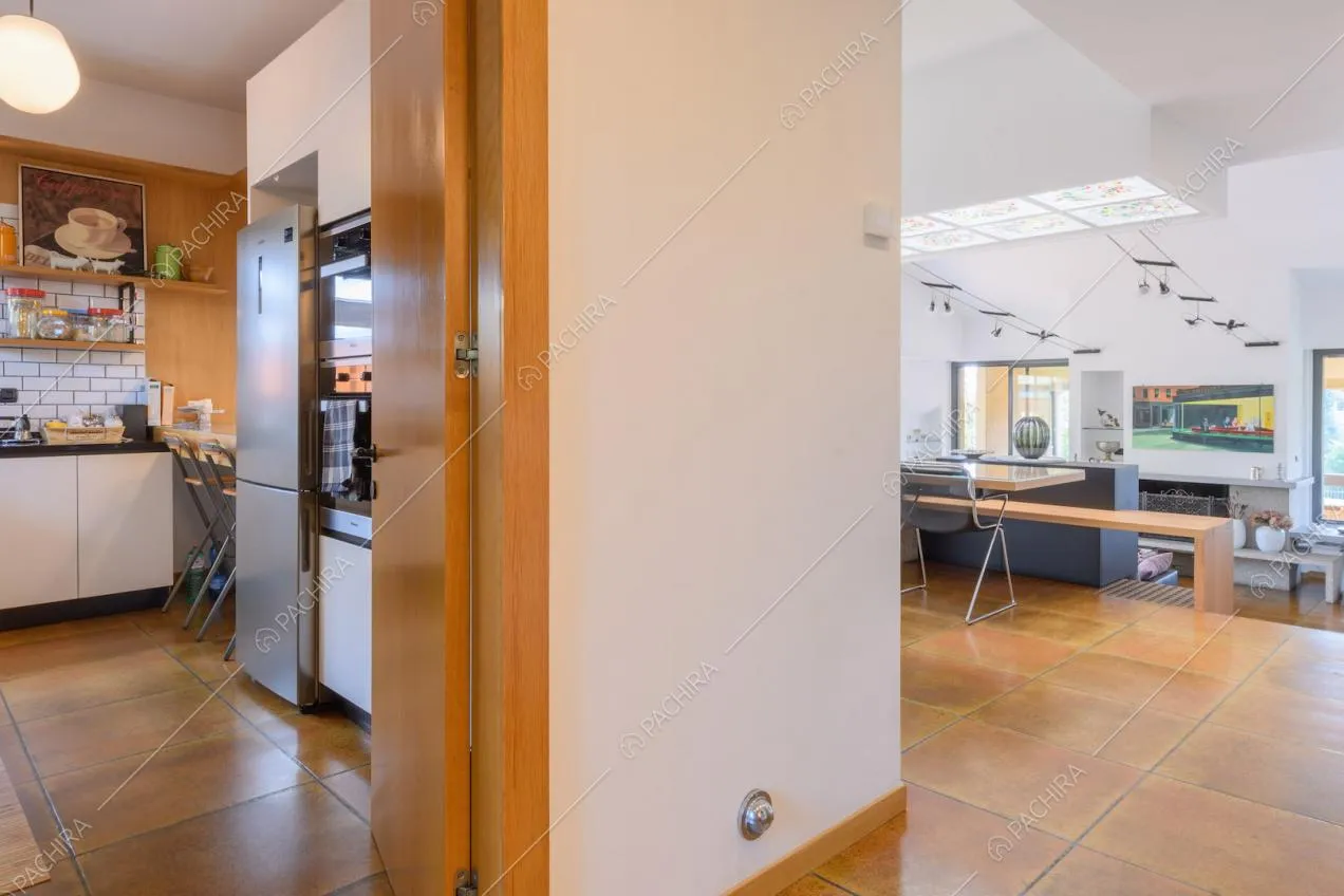 Cucina e zona living con pavimento in piastrelle marroni e pareti bianche