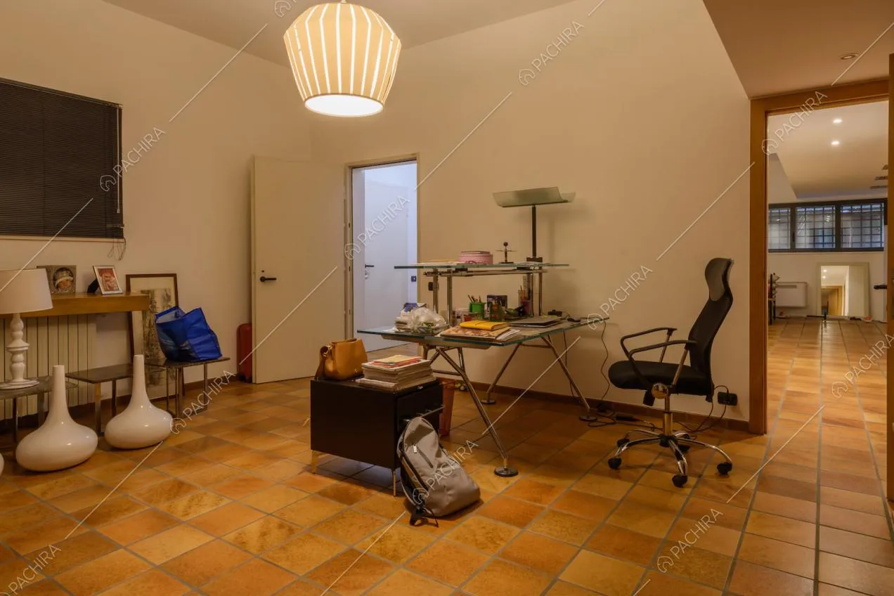 Studio con pareti bianche nella taverna e scorcio sulla zona living
