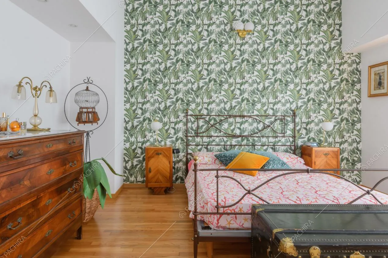 Camera da letto matrimoniale con carta da parati e pavimento in parquet