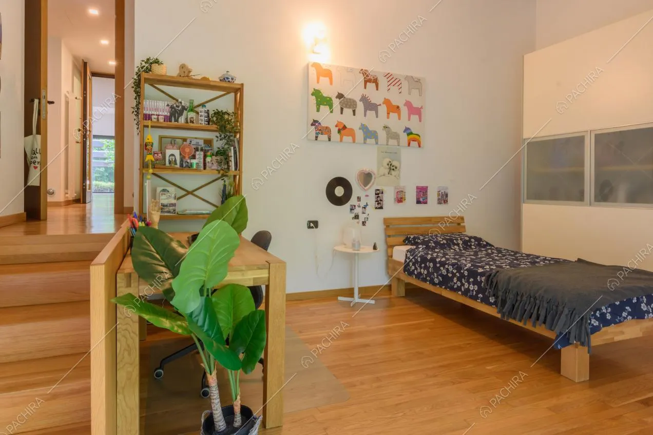 Camera con letto singolo, pavimento in parquet e scale in legno