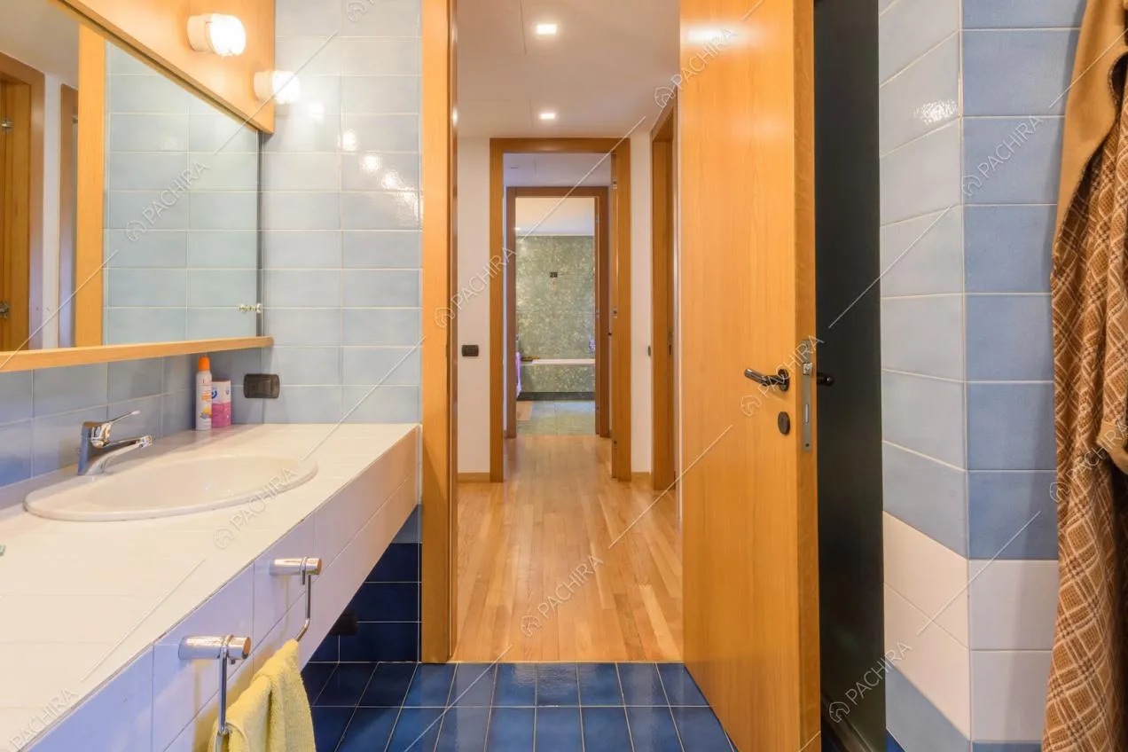 Doppio lavandino nel bagno con pareti e pavimento in piastrelle blu