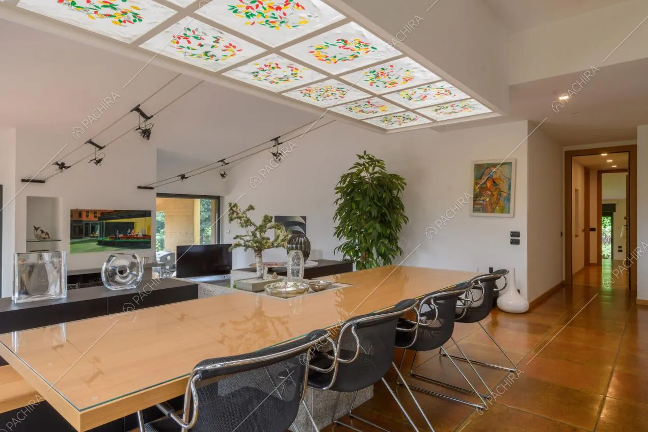 Tavolo da pranzo e sedie di design nella luminosa zona living con pareti bianche
