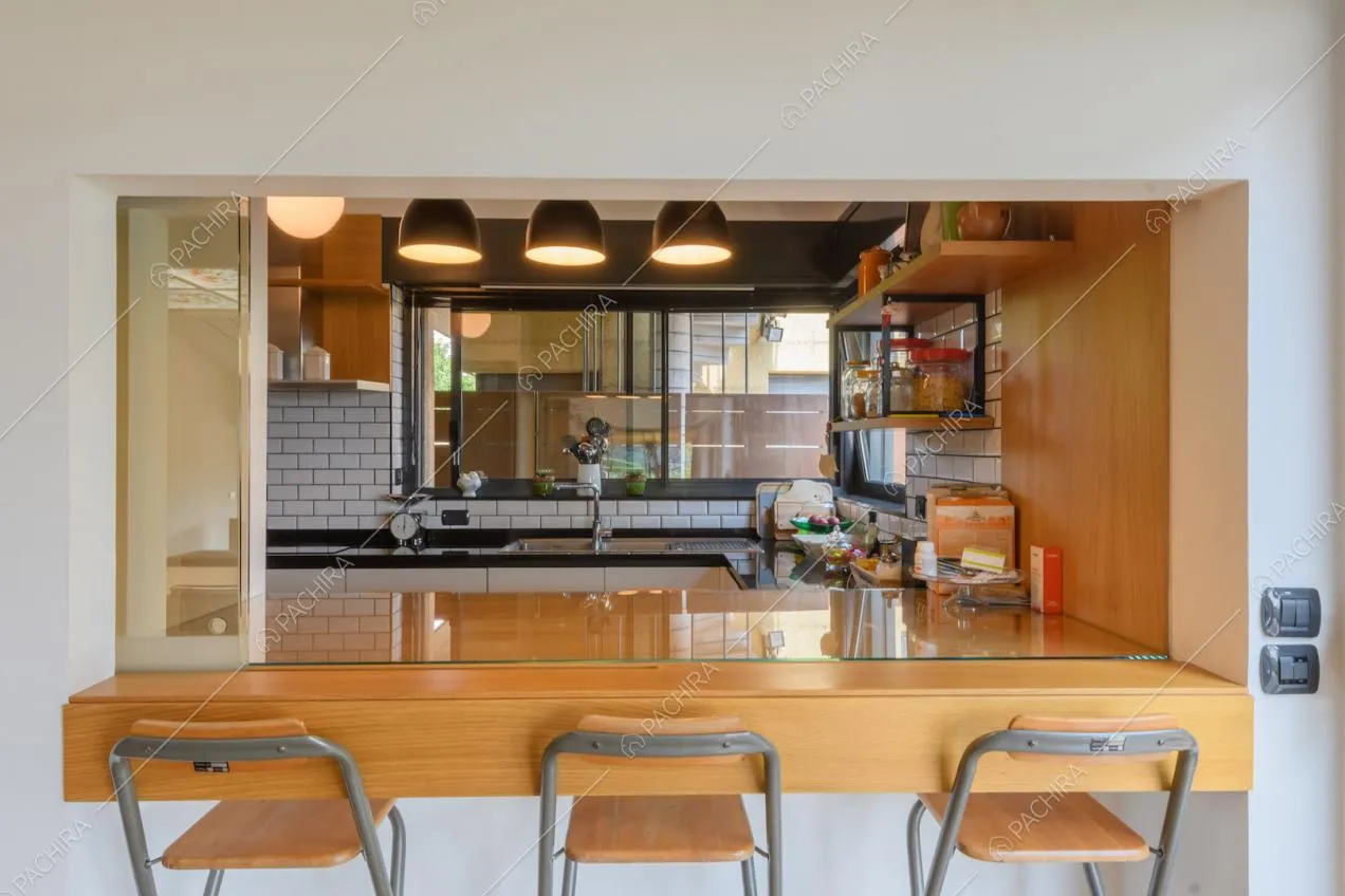 Sgabelli e bancone della cucina con vista sulla parete in piastrelle bianche