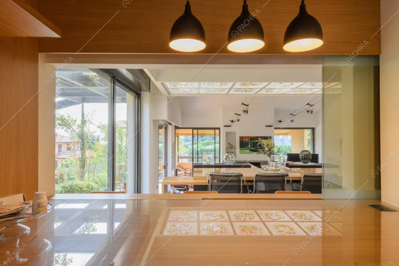 Dal bancone della cucina vista sulla luminosa zona living con tavolo da pranzo