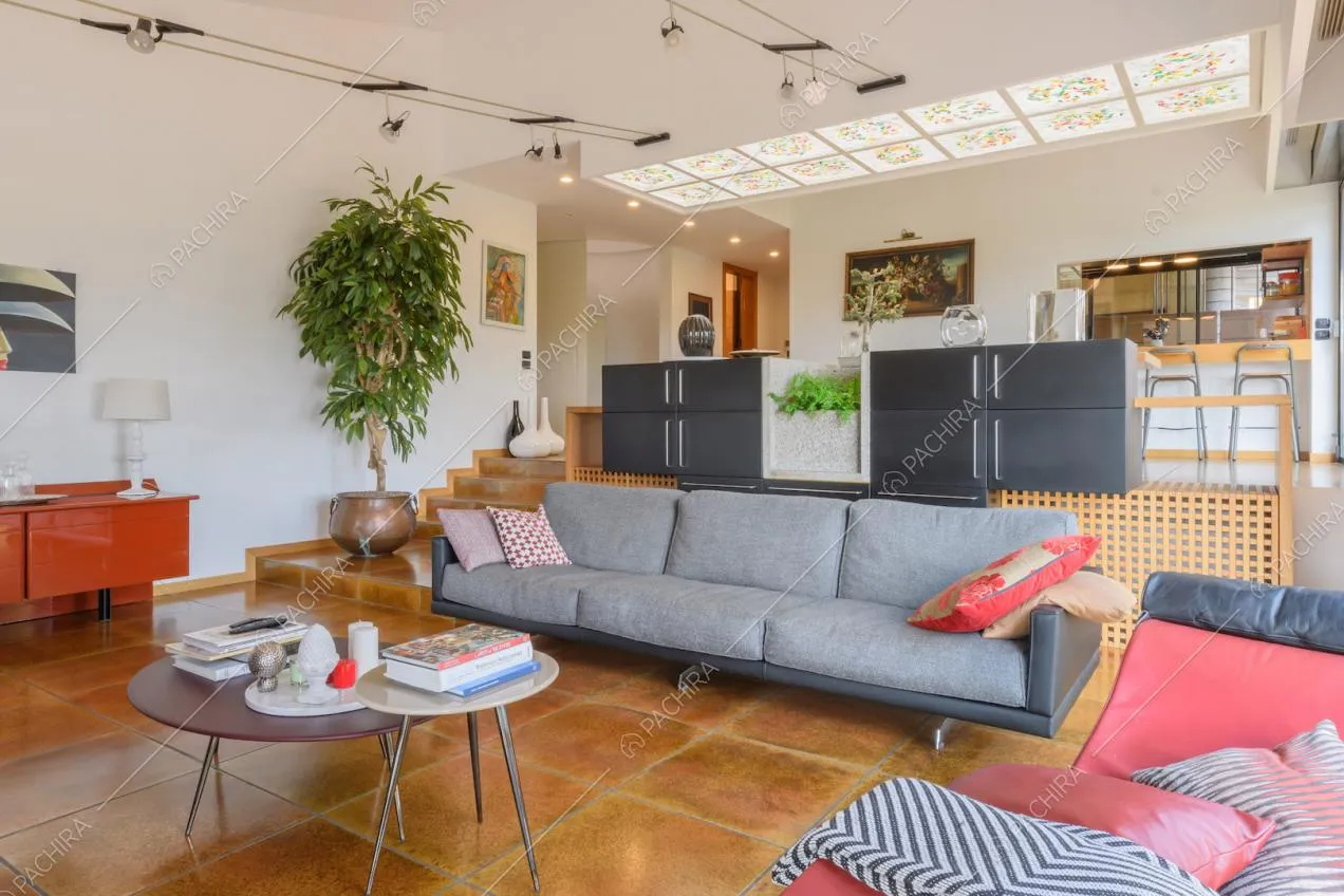 Luminosa zona living con pareti bianche, tavolo da pranzo e piastrelle marroni