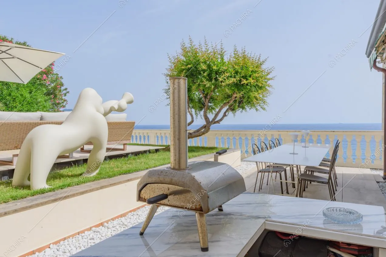 Banco da bar sulla terrazza con tavolo da pranzo bianco e vista mare