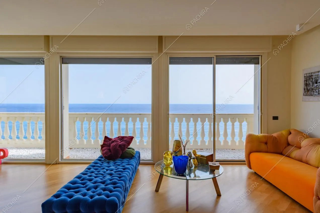 Pouf colorati, vetrate, pavimento in parquet e vista sul mare