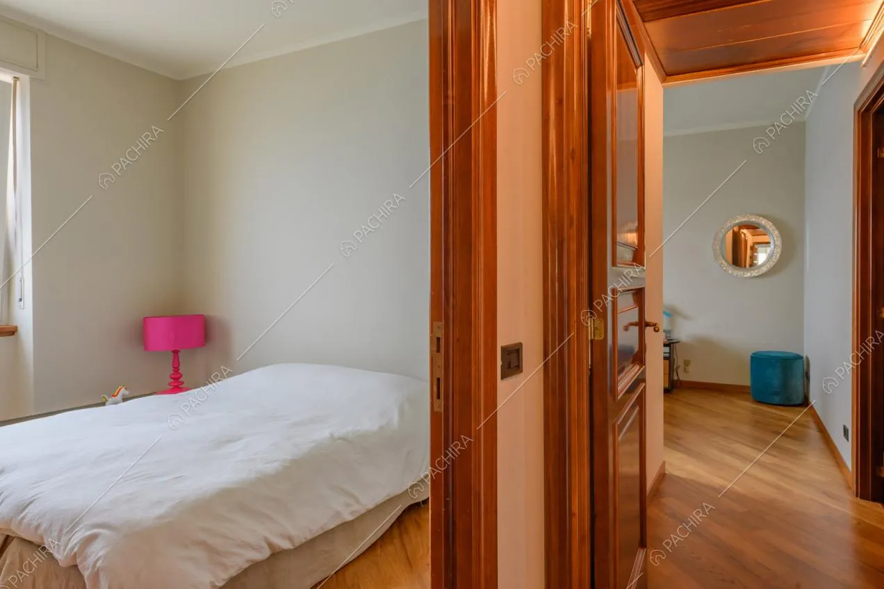 Camera da letto dalle pareti beige e con pavimento in parquet