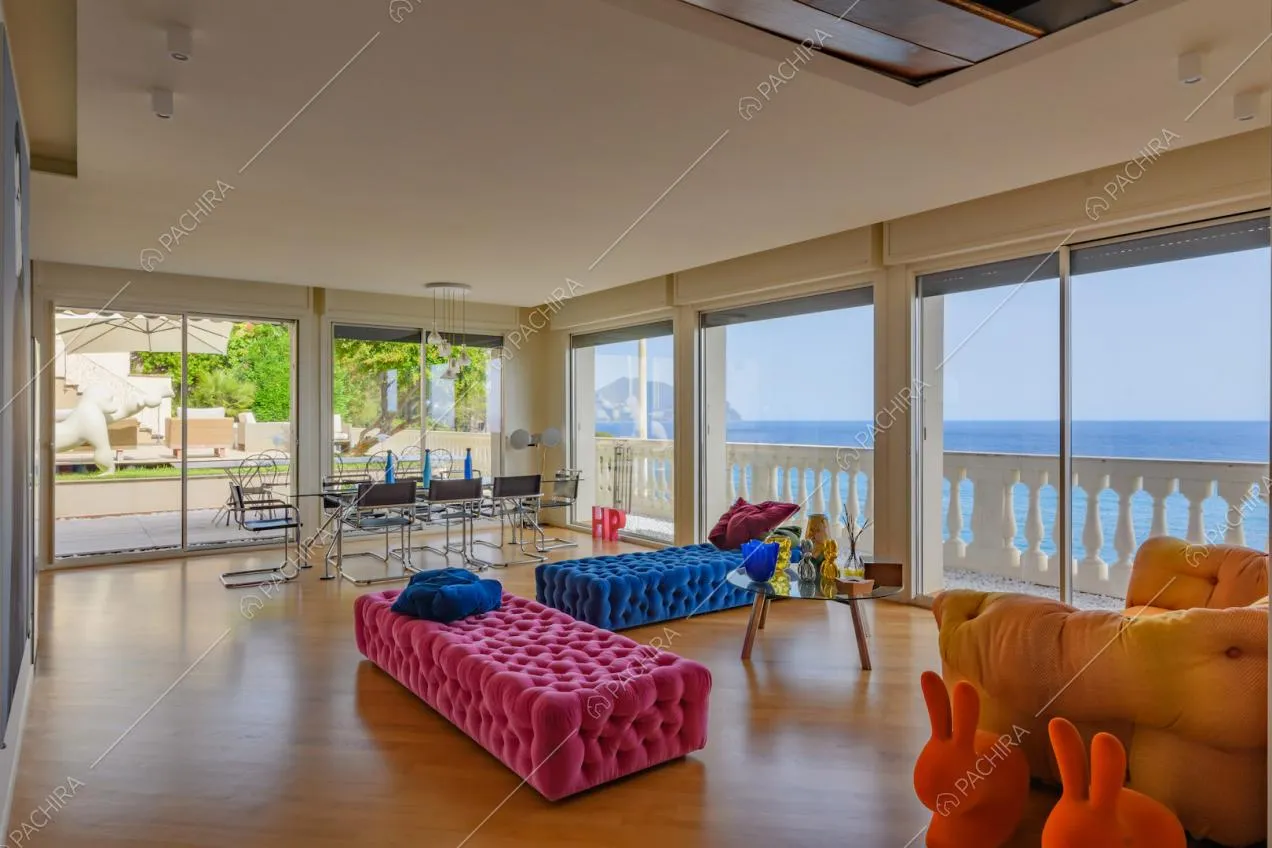 Luminosa zona living con pouf fucsia e blu, vetrate e pavimento in parquet