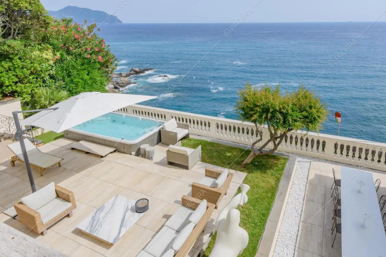 Terrazza con tavolo da pranzo, vasca idromassaggio e vista sul mare