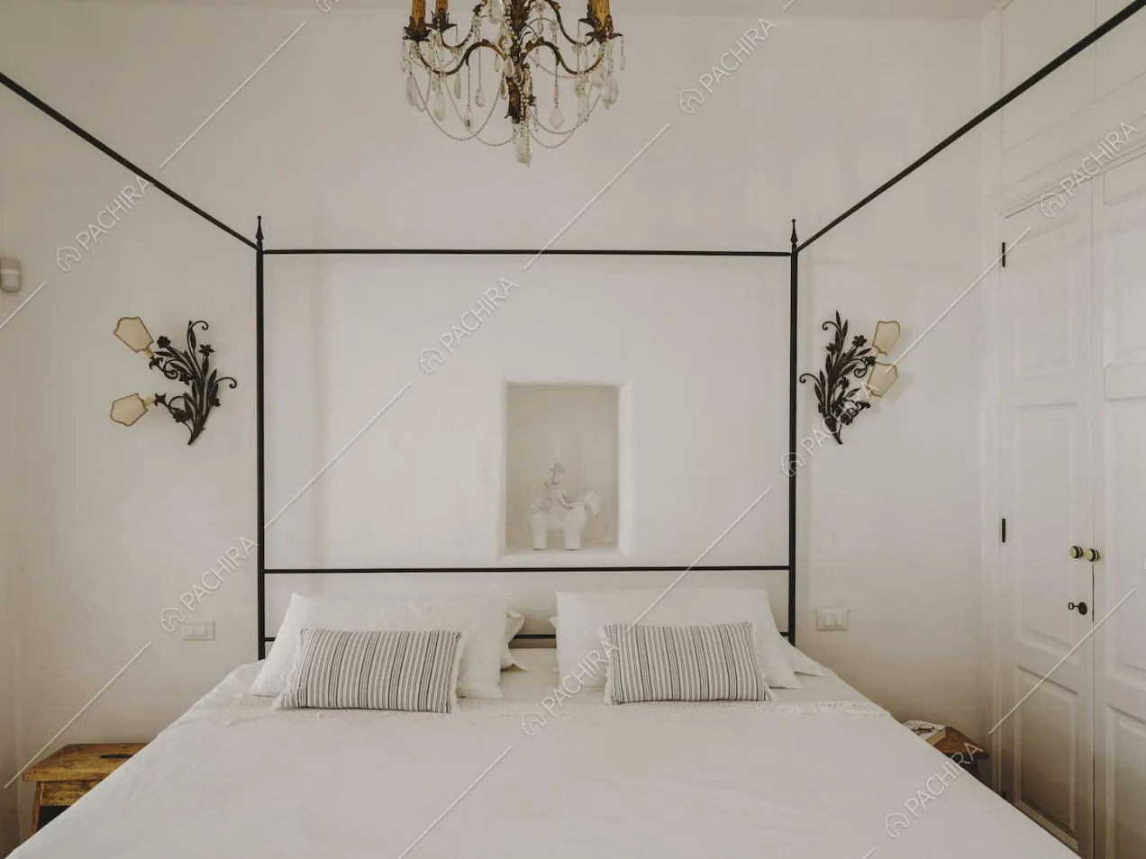 Letto matrimoniale a baldacchino e armadi con boiserie nella camera