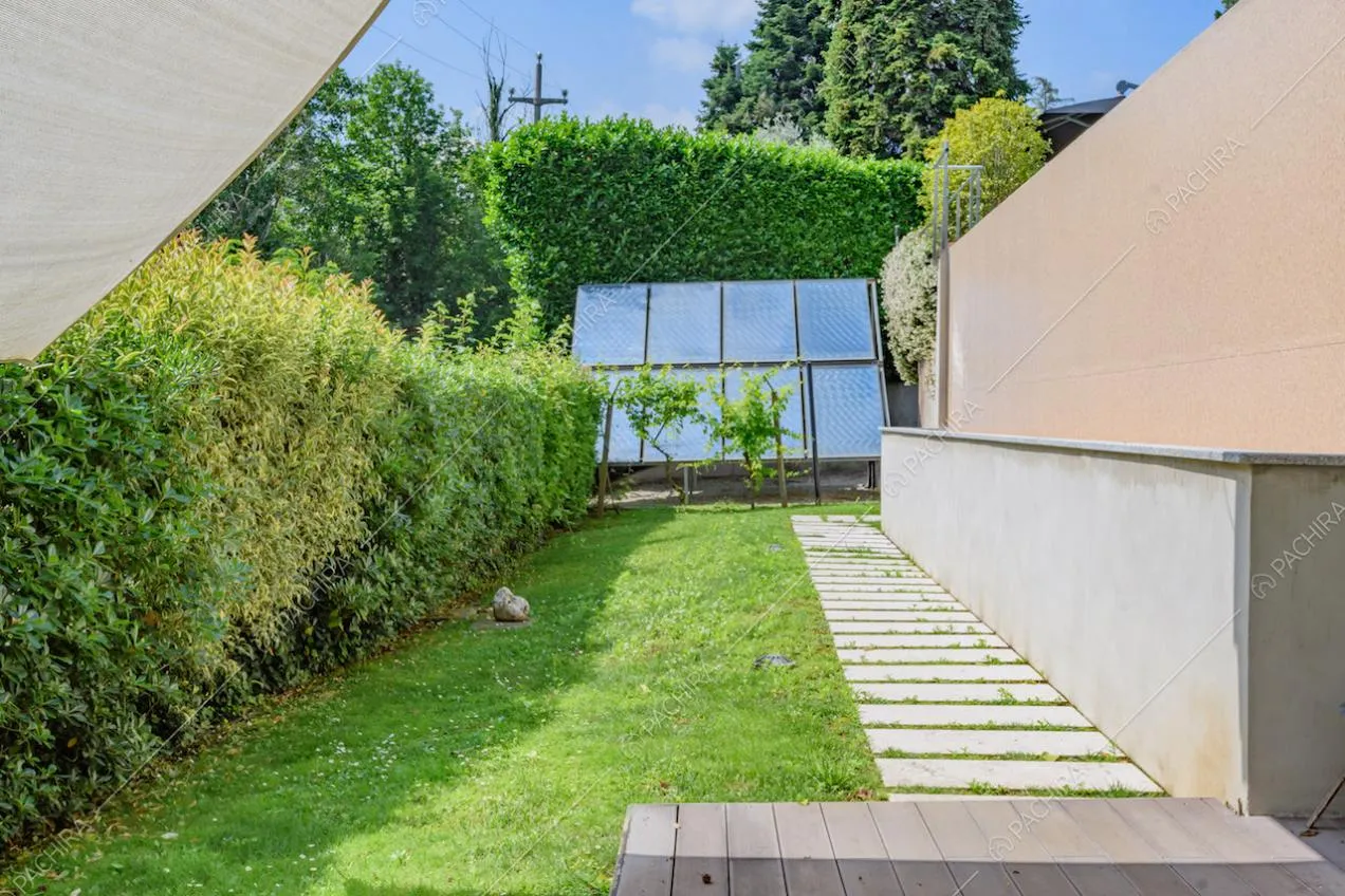 Vialetto, siepe e pannelli solari nel giardino della location