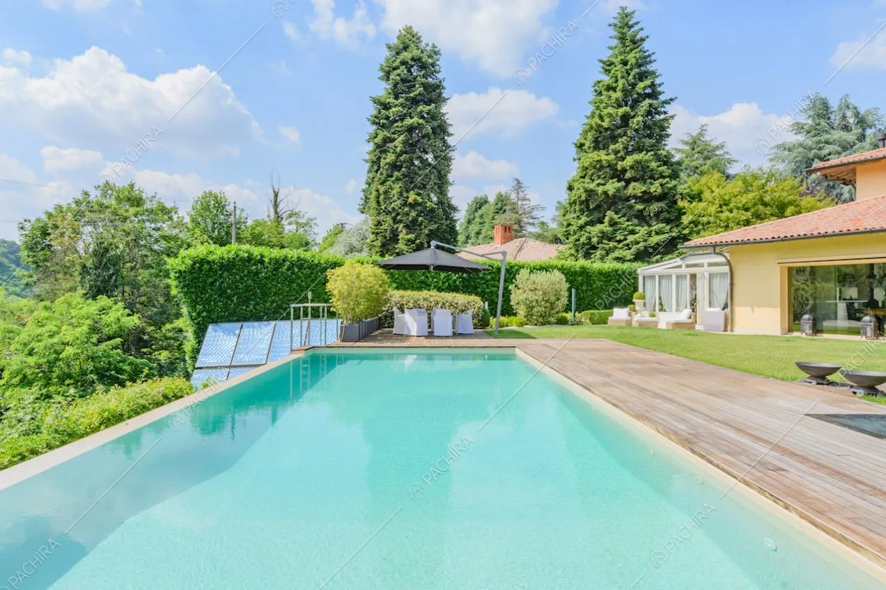 Grande piscina a sfioro con pavimento in legno