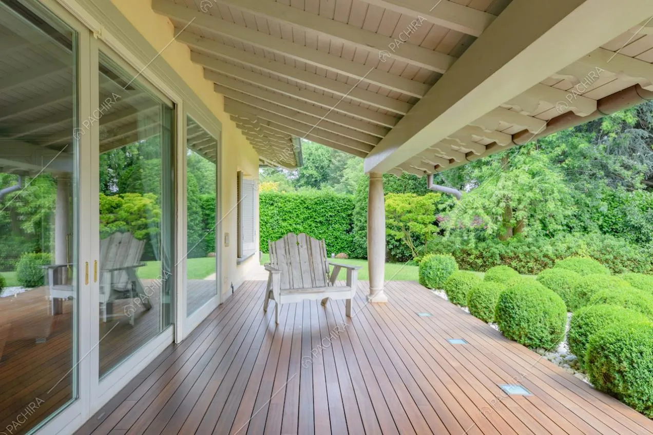 Pavimento in parquet da esterni nella veranda con travi a vista bianche sul soffitto