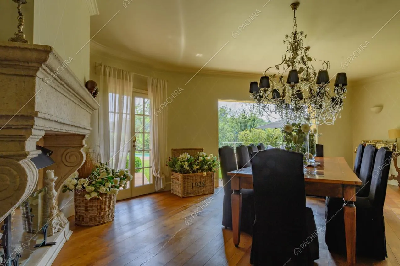 Tavolo da pranzo in legno ed eleganti sedie nere nella sala da pranzo con camino