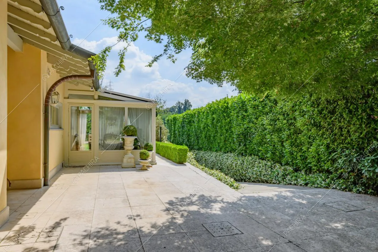 Cortile pavimentato con vista sulla siepe e sulla veranda