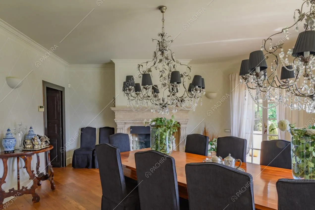 Sala da pranzo con lampadari antichi, pareti bianche e camino