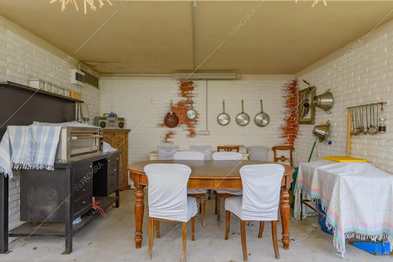 Pareti in mattoncini bianchi e tavolo da pranzo nella veranda