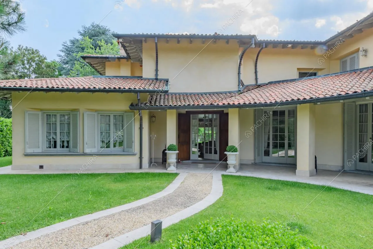 Vialetto in ciottoli, portico e vista sulle porte-finestre della villa