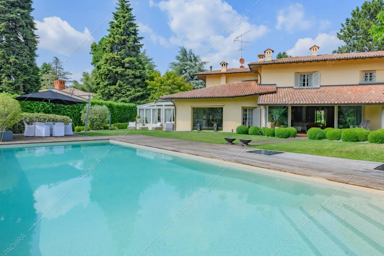 Grande piscina nel giardino della villa con vista sulla veranda
