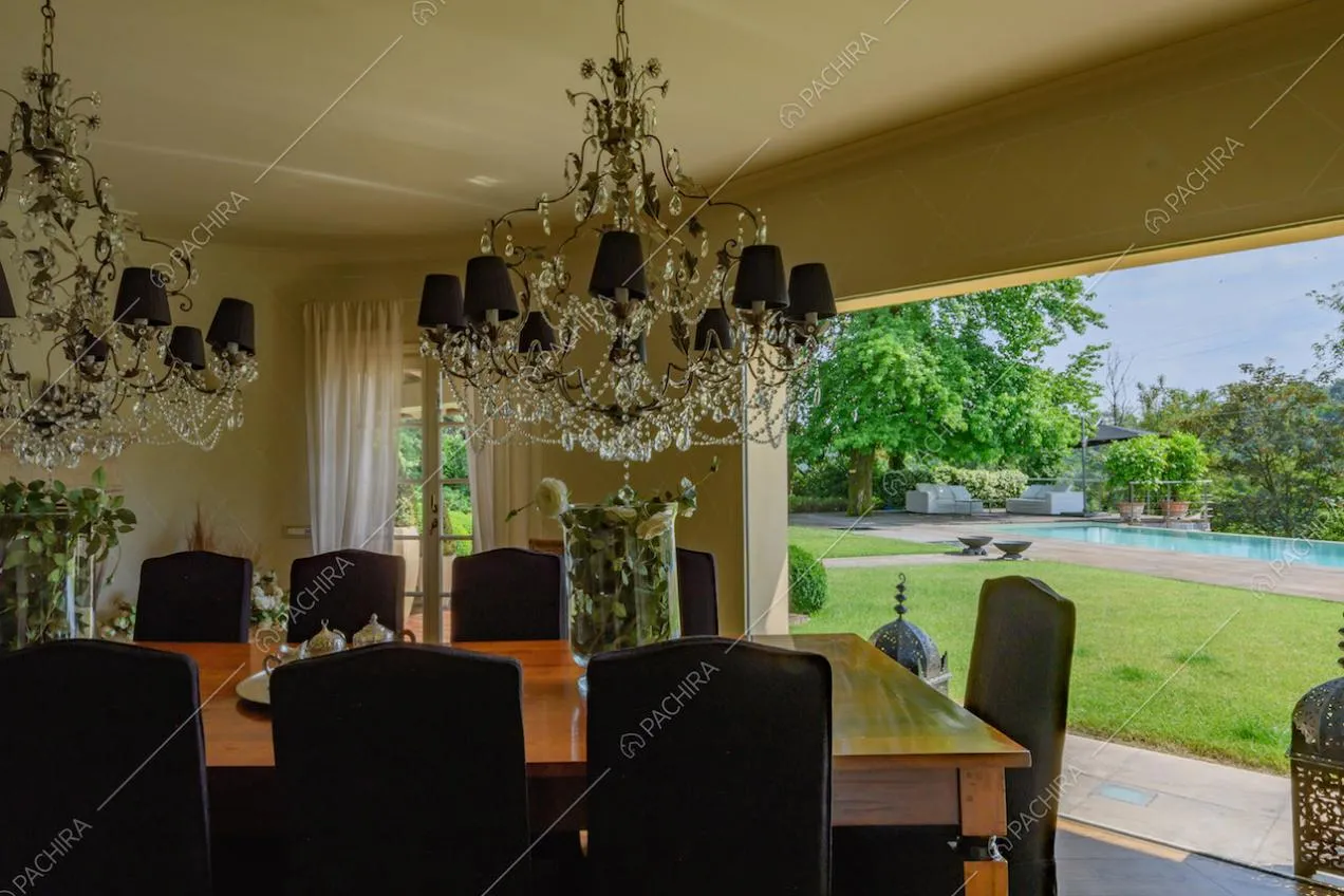 Vista sul giardino con piscina dalla grande vetrata della sala da pranzo