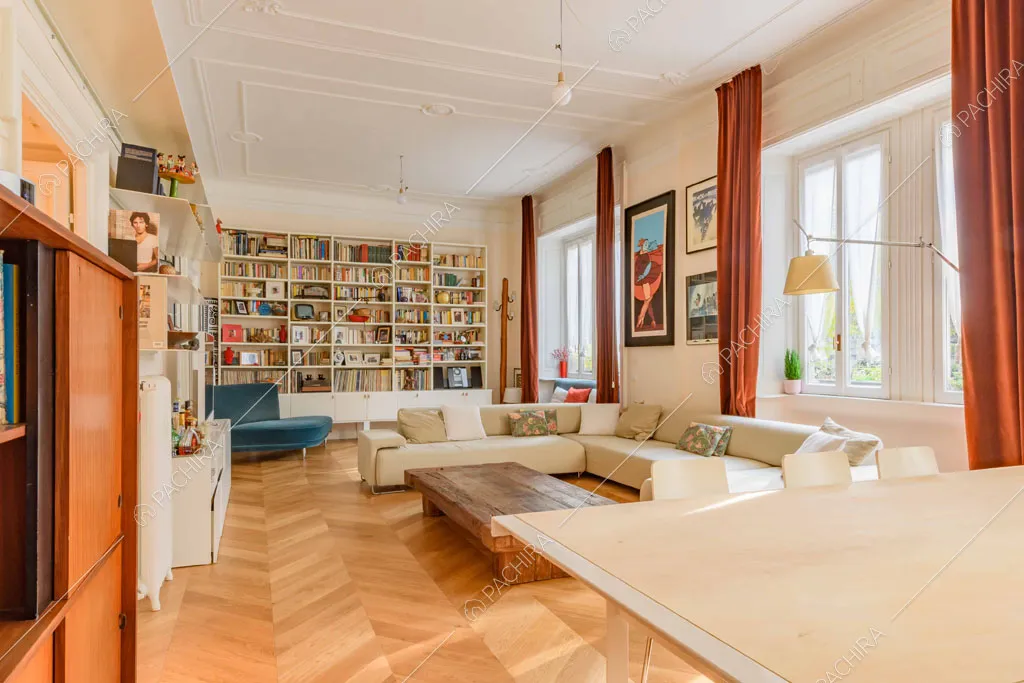 Tavolo da pranzo nella luminosa zona living con tende rosse e boiserie sul soffitto