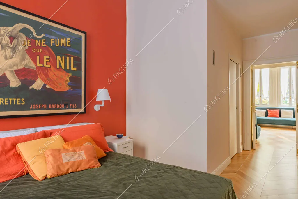 Camera da letto matrimoniale con parete rossa e pavimento in parquet