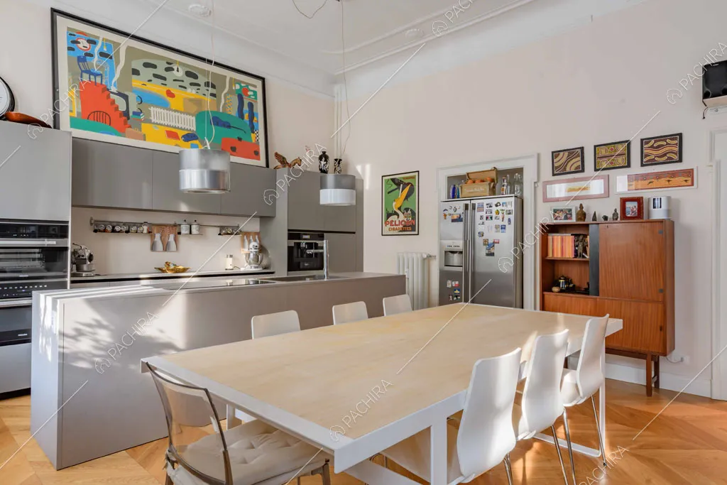 Tavolo da pranzo in metallo bianco nella sala con cucina a vista a isola