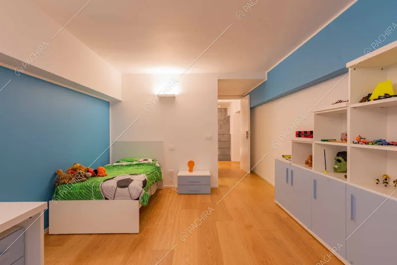 Parete azzurra nella camera da letto dei bambini con pavimento in parquet