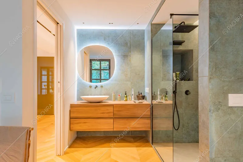 Bagno con piastrelle verderame, box doccia e pavimento in parquet a spina di pesce