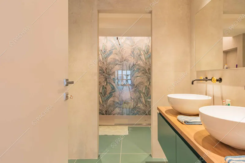 Bagno con pavimento in piastrelle verdi, doppio lavandino e box doccia