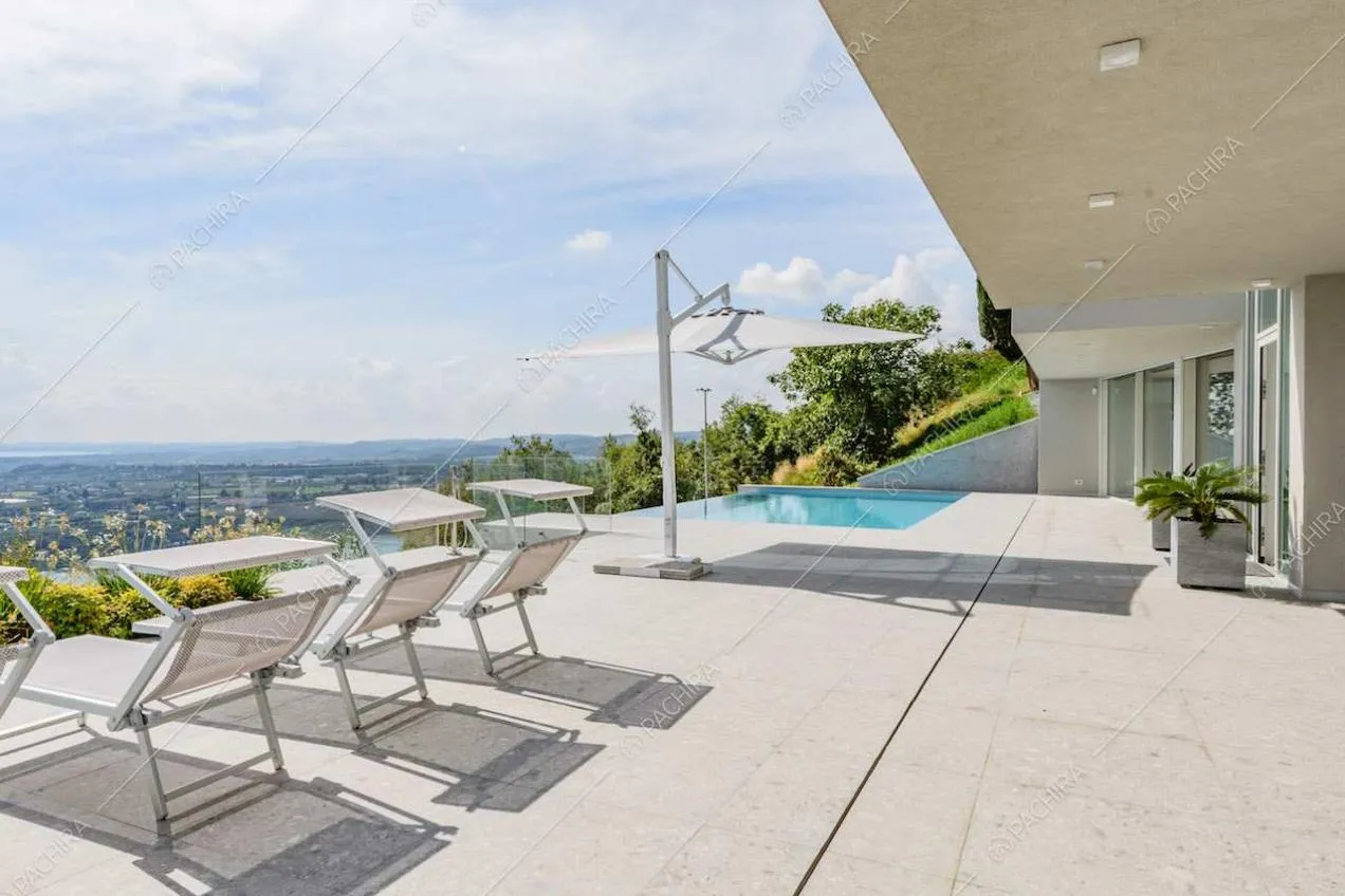 Grande terrazza con lettini, piscina e vista sul lago
