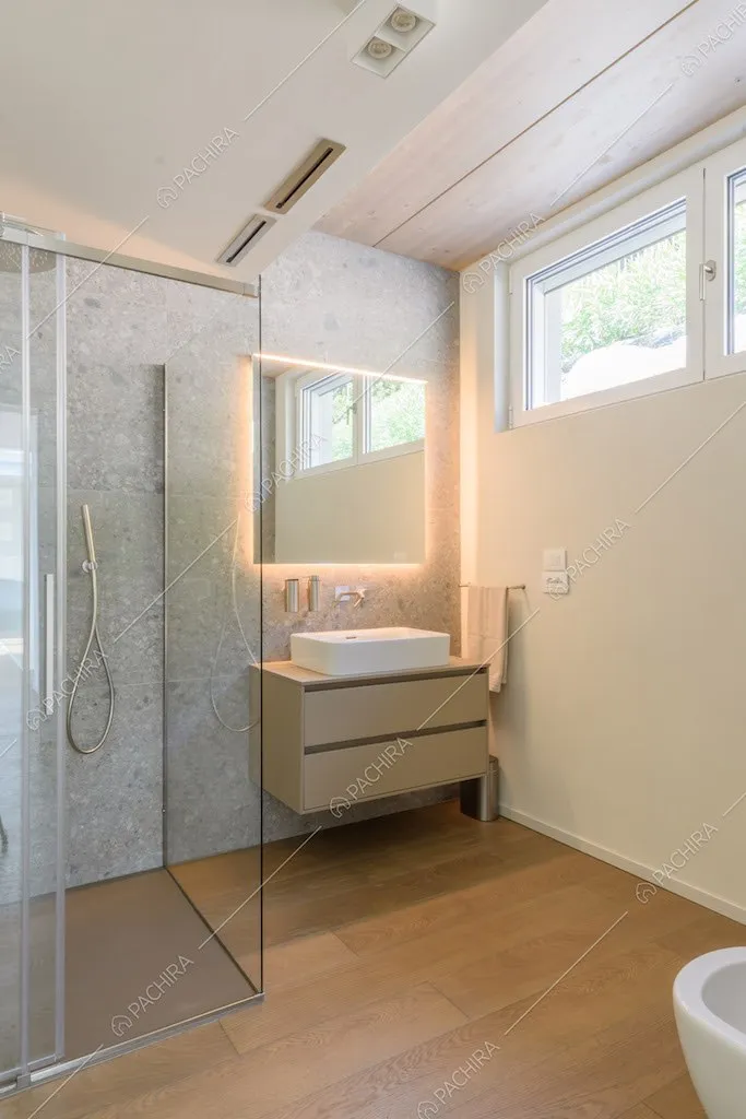 Bagno con box doccia, specchio retroilluminato e pavimento in parquet