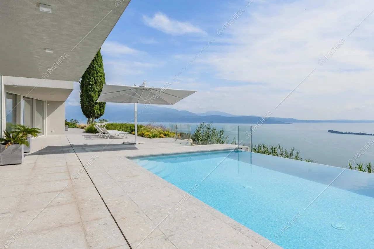 Grande terrazza con piscina a sfioro e vista sul lago