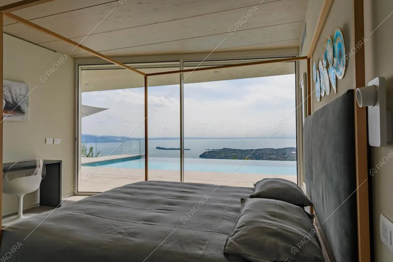 Camera da letto matrimoniale con baldacchino e vetrata con vista sul lago
