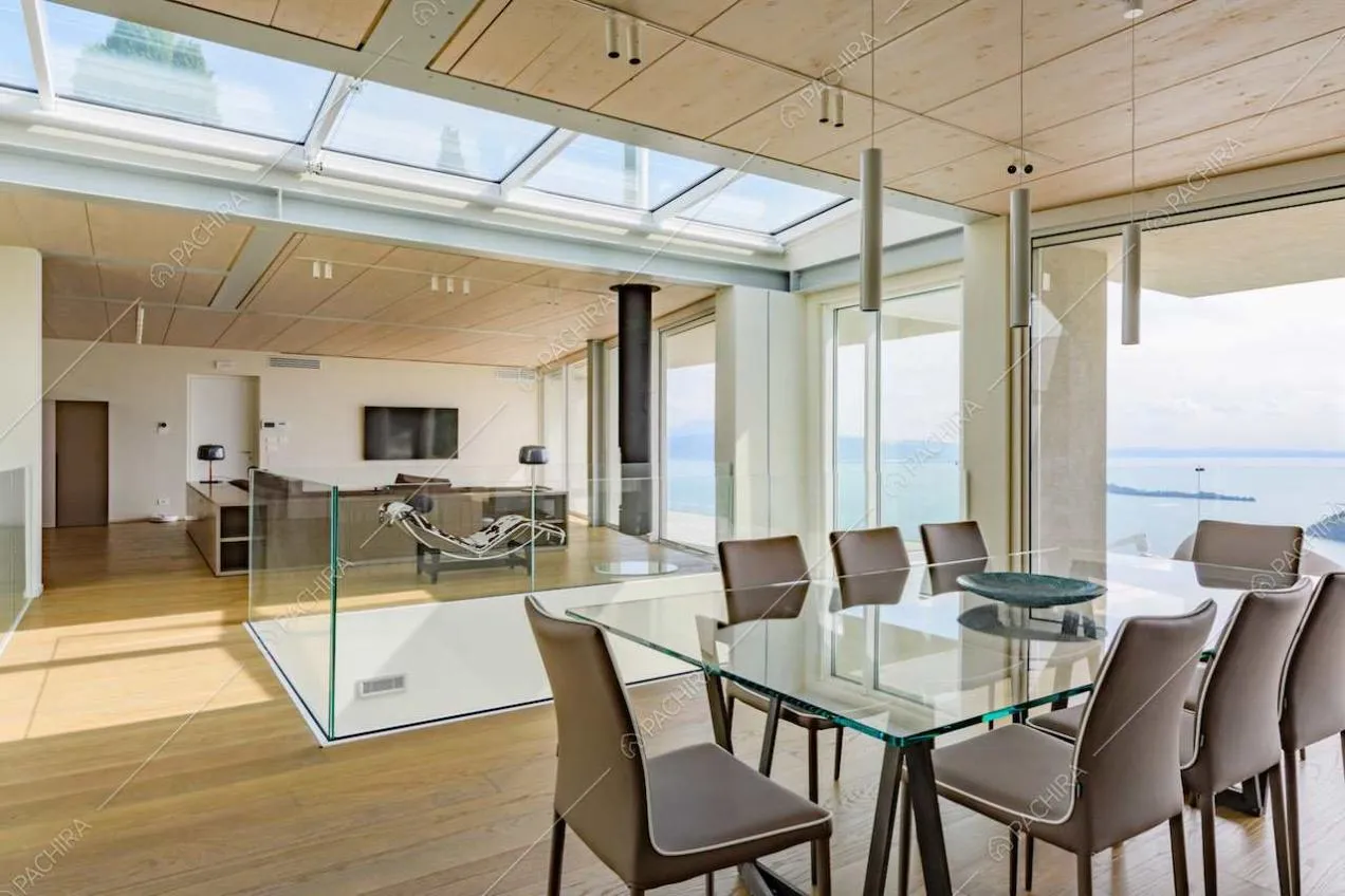 Tavolo da pranzo nella grande sala con pavimento in parquet e lucernari