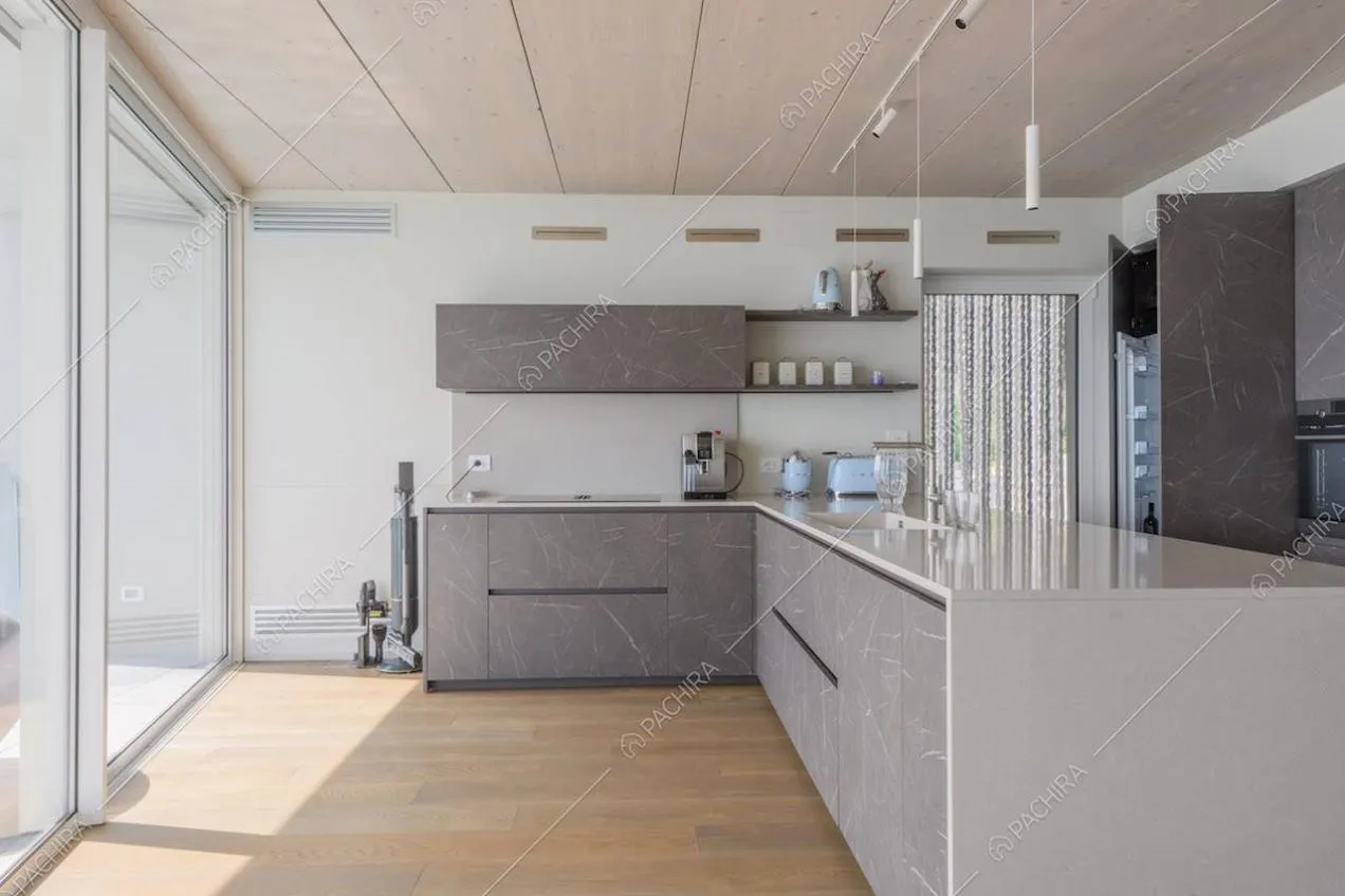 Cucina grigia a penisola con fornelli a induzione e pavimento in parquet